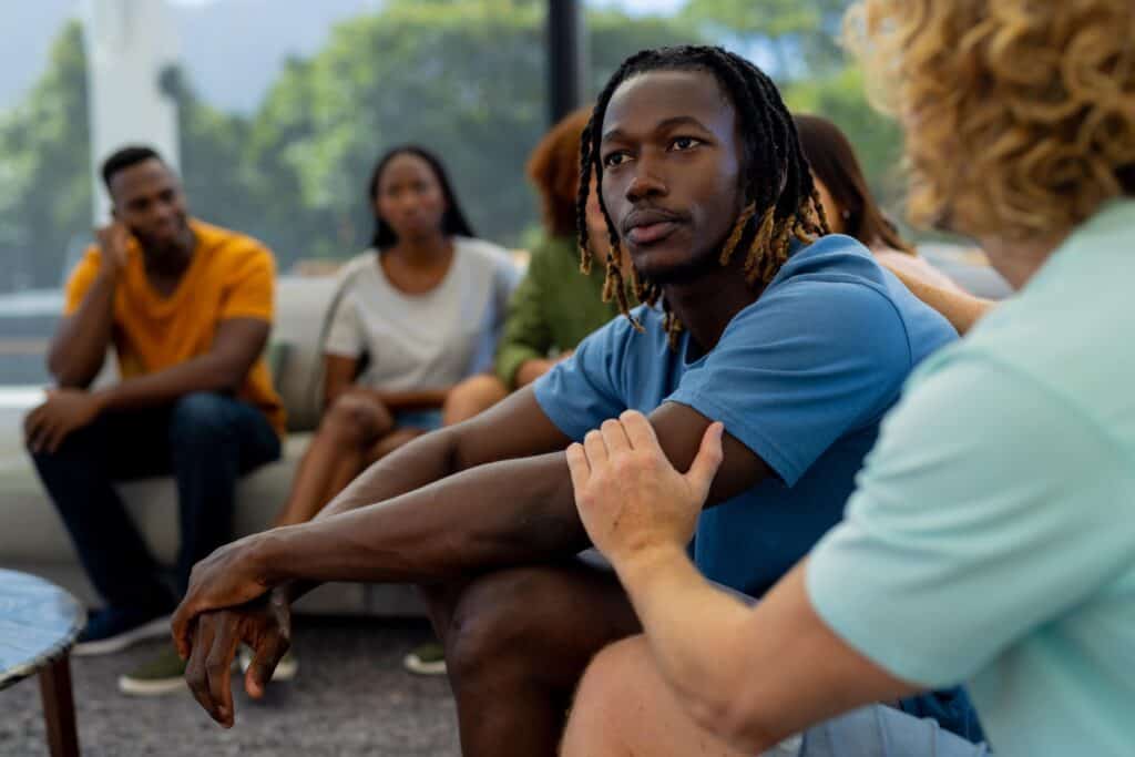 A man is comforted at a group exercise during alcohol addiction treatment in Houston.