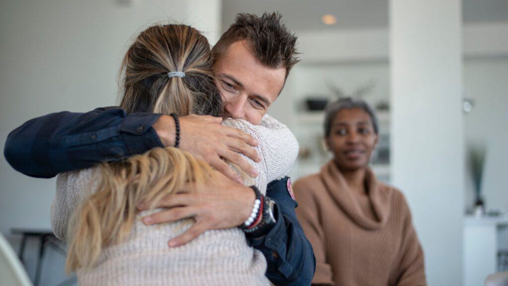 A man hugs his loved one during a family therapy session in Houston.