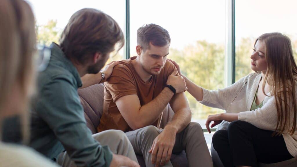 A man receiving support from friends at bipolar disorder treatment in Houston. 