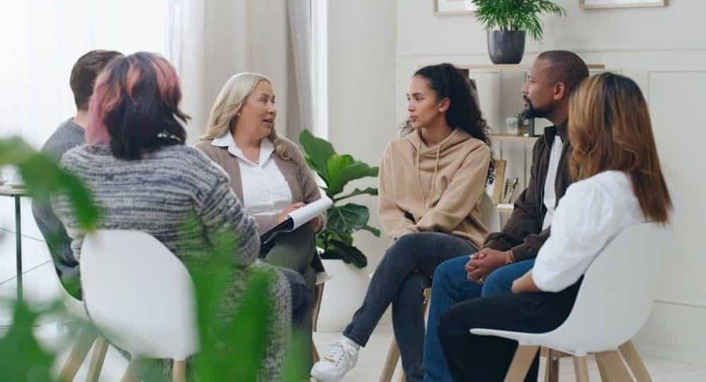  A diverse group of individuals engaged in conversation while seated in a circle, fostering communication and connection