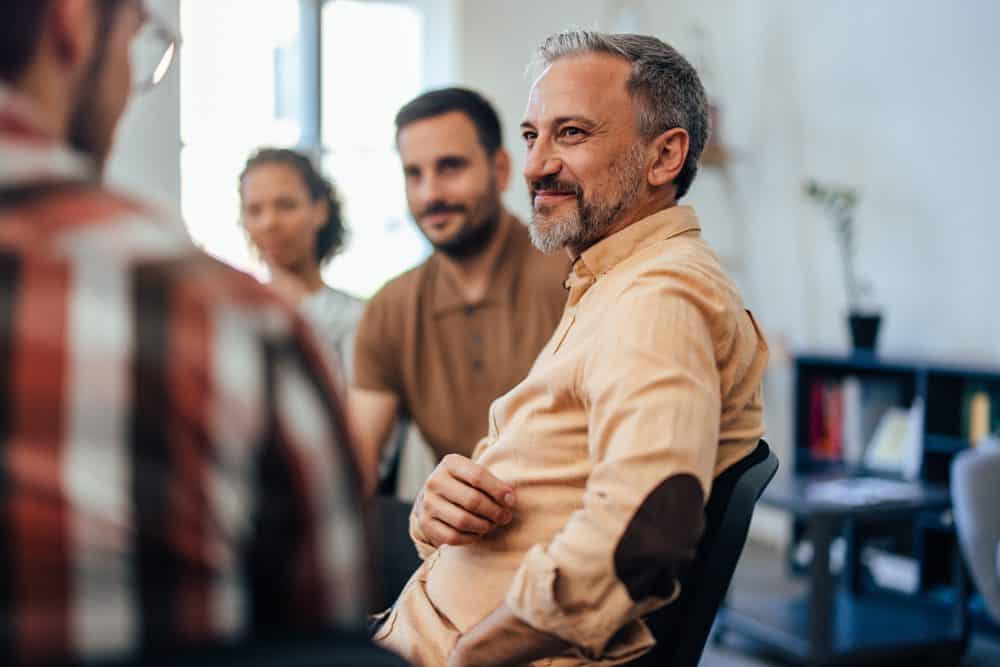 group-of-individuals-smiling-in-therapy