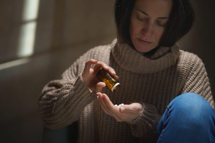 a-woman-pouring-opioids-into-her-hand