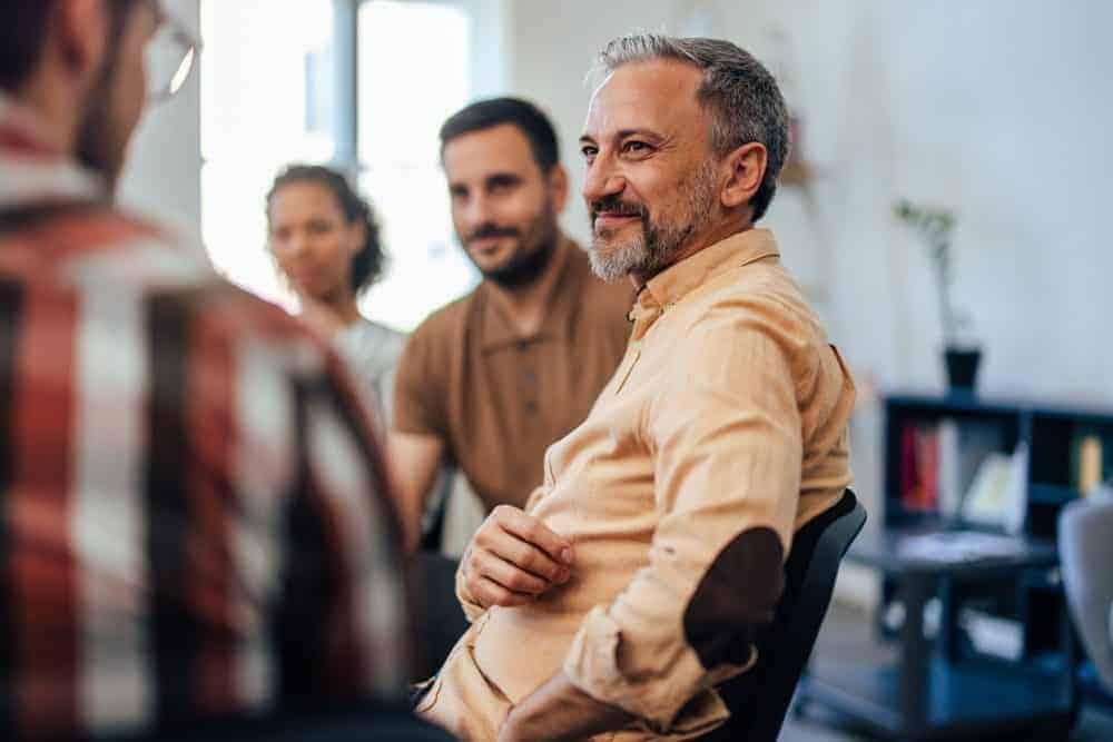 Group of Individuals Smiling in Therapy