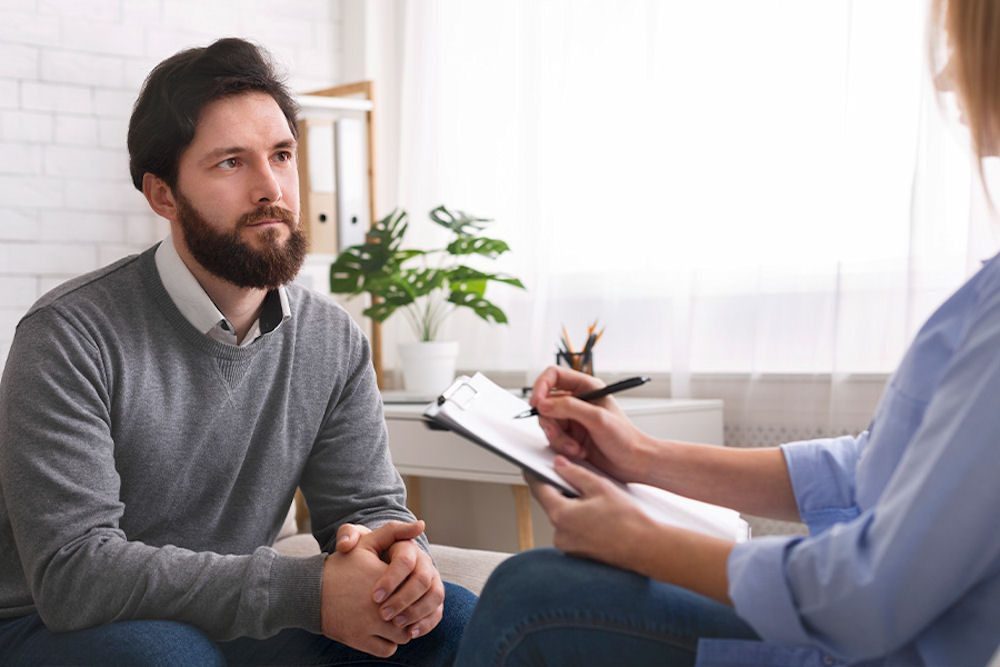 Patient listening to counselor at a men's addiction treatment center