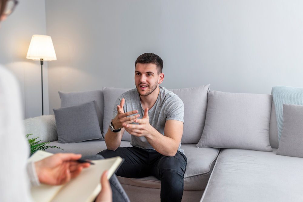 Man opening up during therapy at a men's addiction treatment center