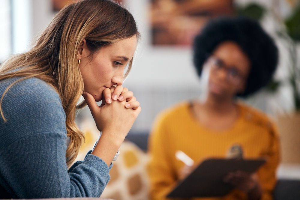 A woman processing difficult emotions in counseling while exploring trauma therapy techniques with her therapist.