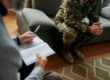 a veteran sits in therapy, discussing the best treatments for PTSD with her therapist